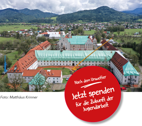 Mit Regenplanen auf den Dächern versehenes Klostergebäude mit einem Spendenaufruf