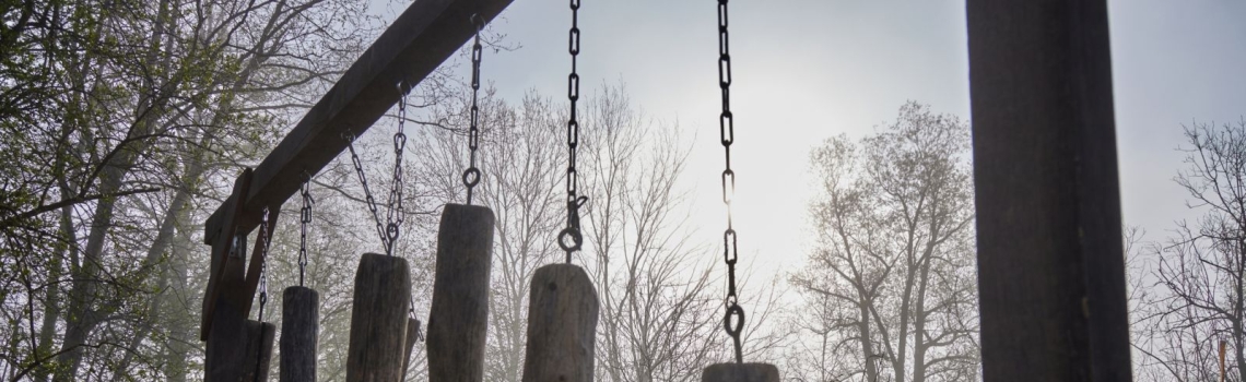 Meterhohes Musikinstrument aus Holzbalken und Metall im Naturlehrpfad des ZUK Benediktbeuern 