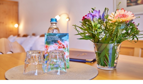 Einladende Dekoration mit Blumen und Getr&auml;nk f&uuml;r Urlauber in einem G&auml;stezimmer des ZUK 