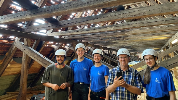Helferinnen und Helfer mit Schutzhelmen im Maierhof des Zentrums für Umwelt und Kultur im Kloster Benediktbeuern 